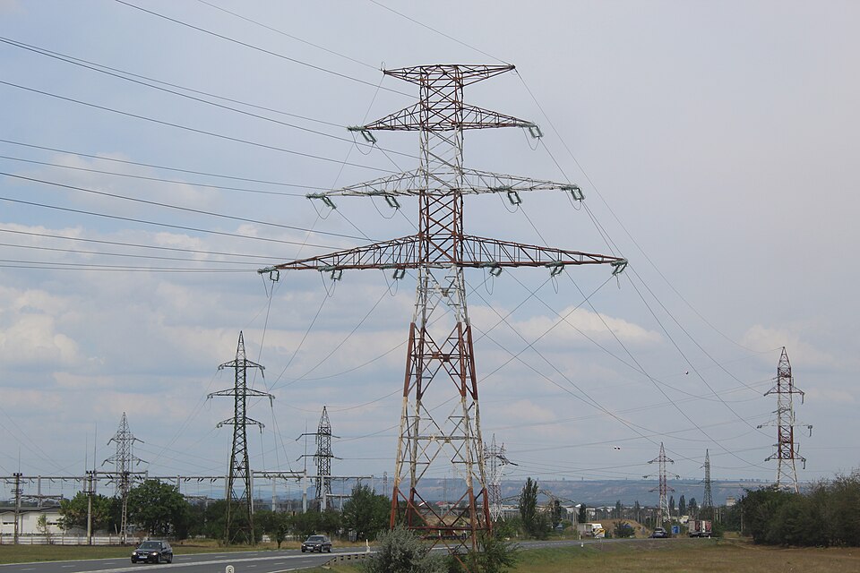 Lattice steel tower of the 750 kV overhead line near Mărășești, Romania, with the substation in the background.