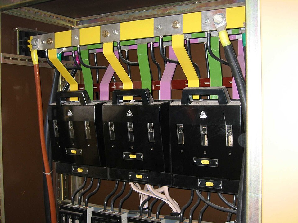Low-voltage main distribution board (200 A) with three-phase busbars (L1/L2/L3 colour-coded) and NH fuse switch-disconnectors.